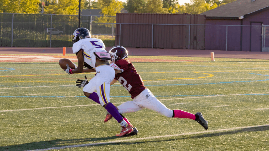 a football player is trying to catch the ball in the field