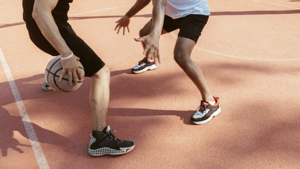 two people playing basketball on an outdoor court