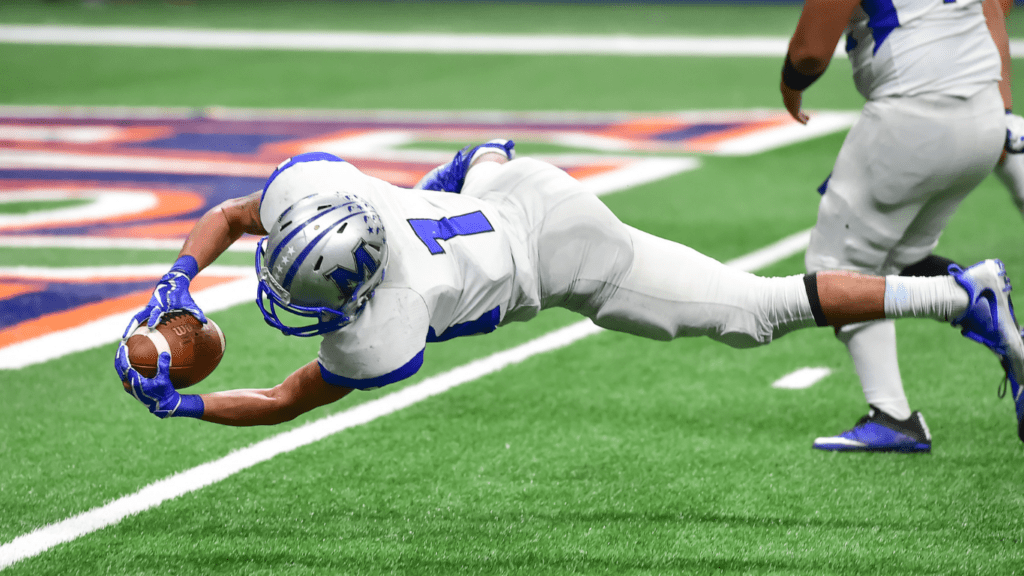 a football player diving for the ball during a game