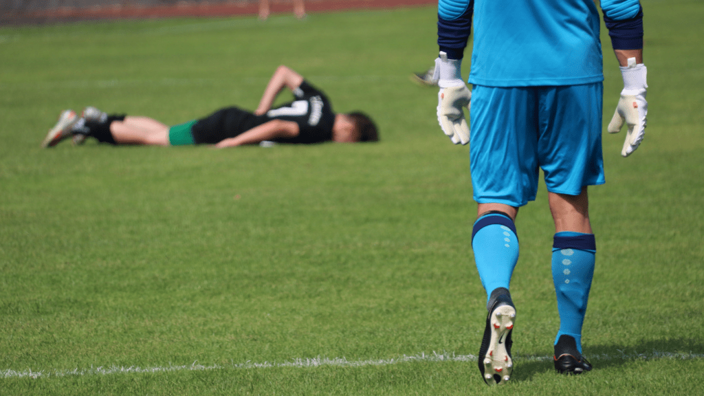 a soccer player is laying on the ground