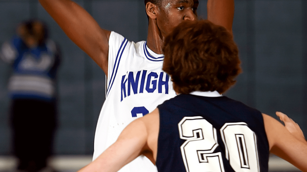 two individuals in purple and white uniforms playing basketball