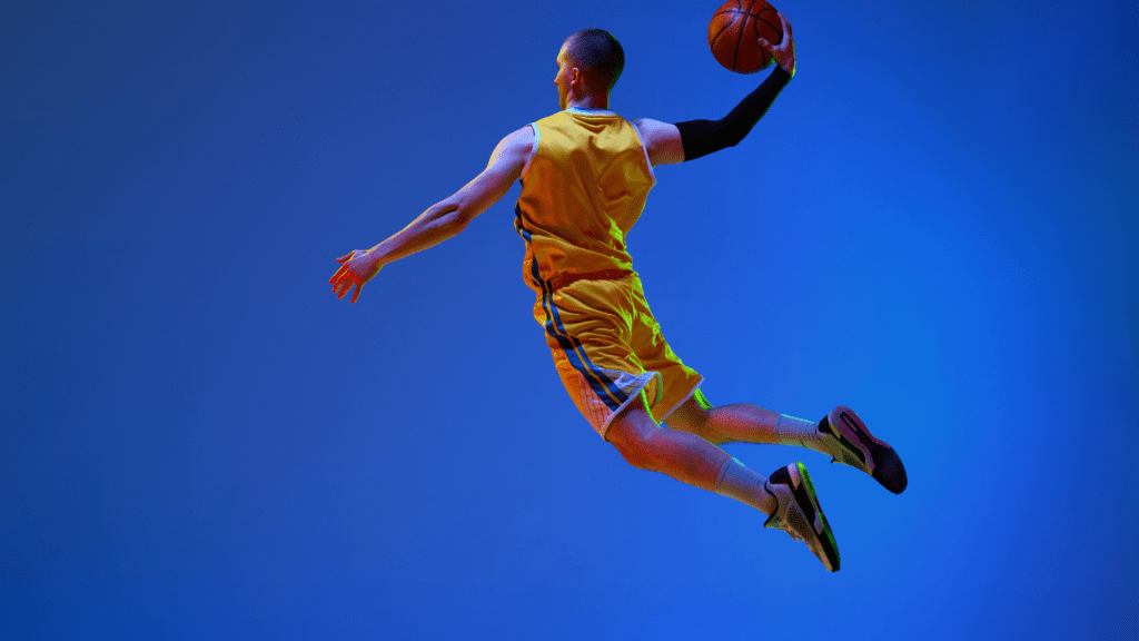 a basketball player in mid air with the ball in his hand