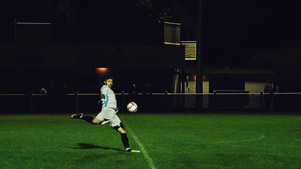 a person kicking a soccer ball on a field