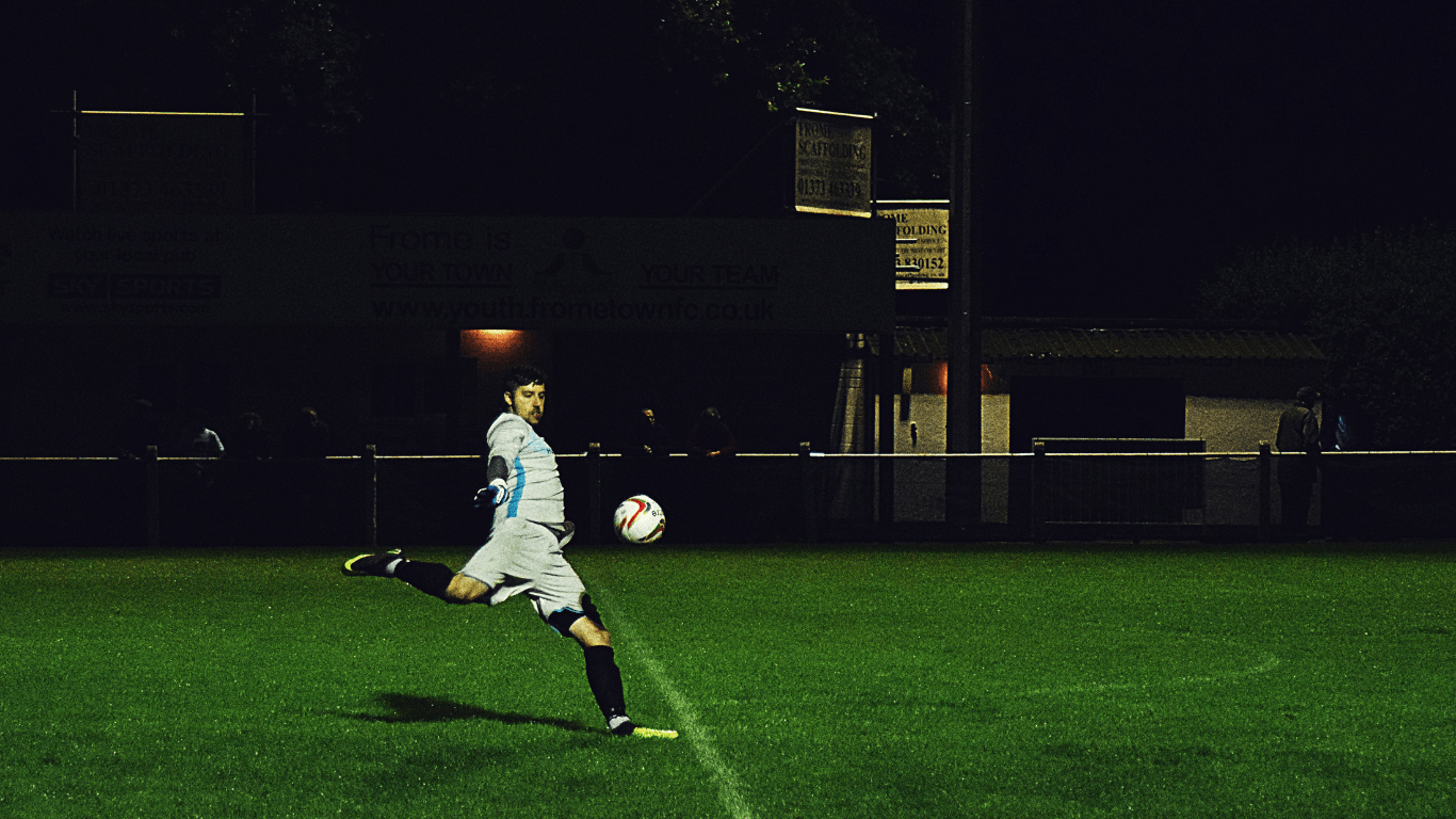a person kicking a soccer ball on a field