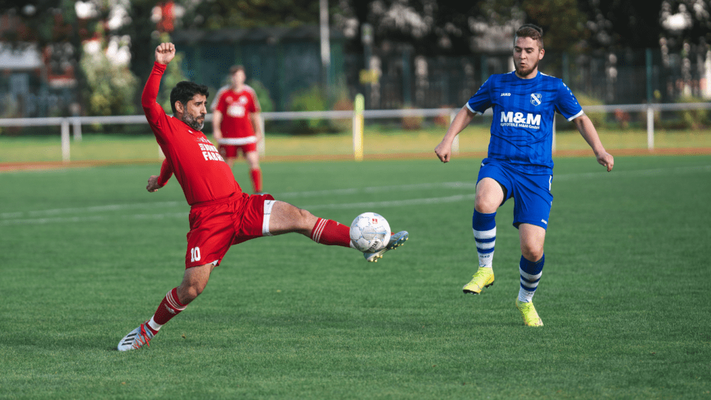 Two people are playing soccer on a field