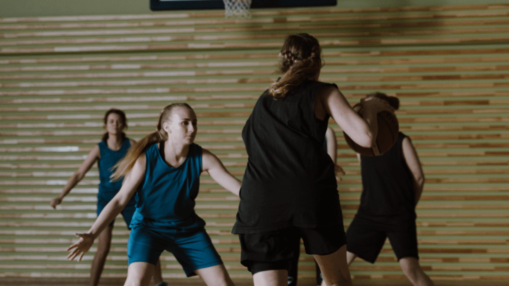 a group of people playing basketball on an indoor court