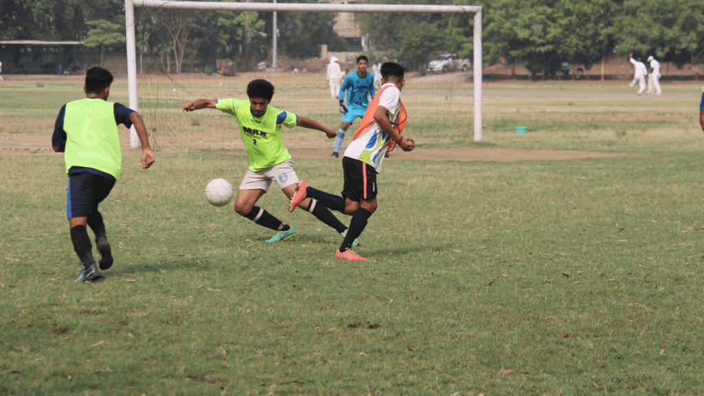 a group of young playing soccer on a field