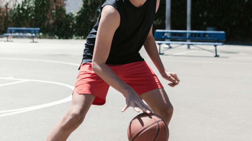 a person is playing basketball on an outdoor court