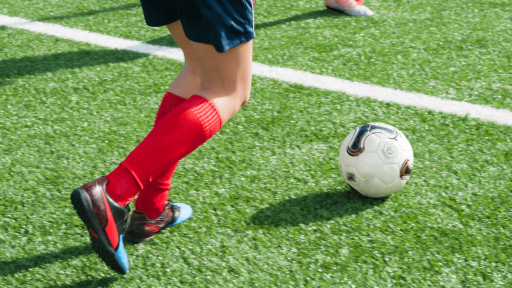 a person kicking a soccer ball on a field