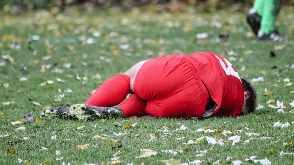 a soccer player is laying on the ground