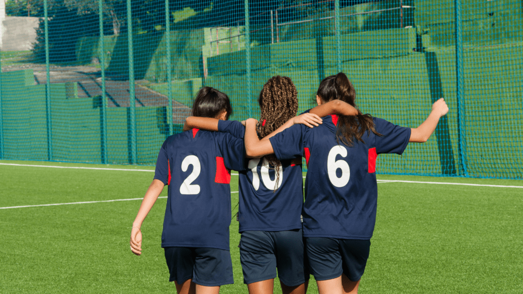 three individuals standing on a soccer field