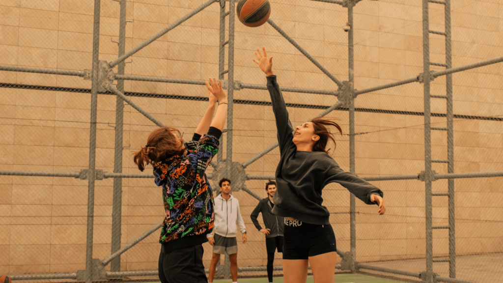 two people playing basketball on an outdoor court