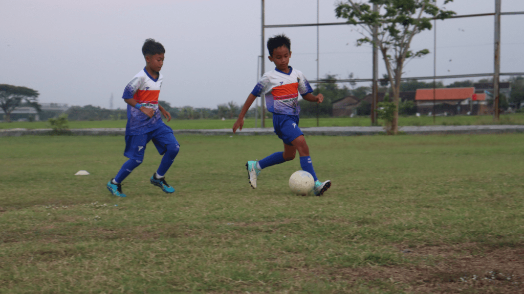 two people playing soccer on a field